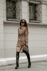 a lady in a brown long double-breasted coat with a belt